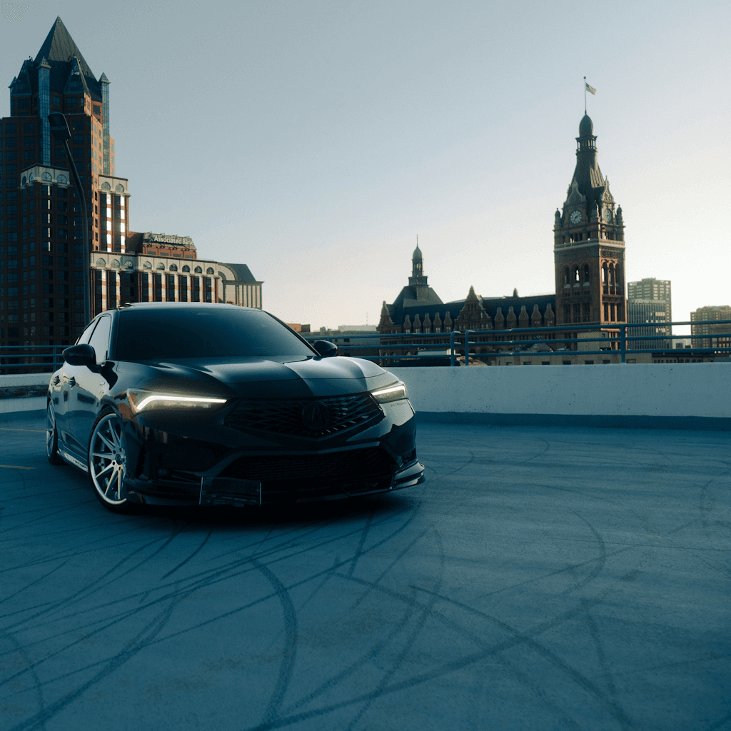 The scene is set on a rooftop parking structure in an urban environment during the serene moments of dusk.