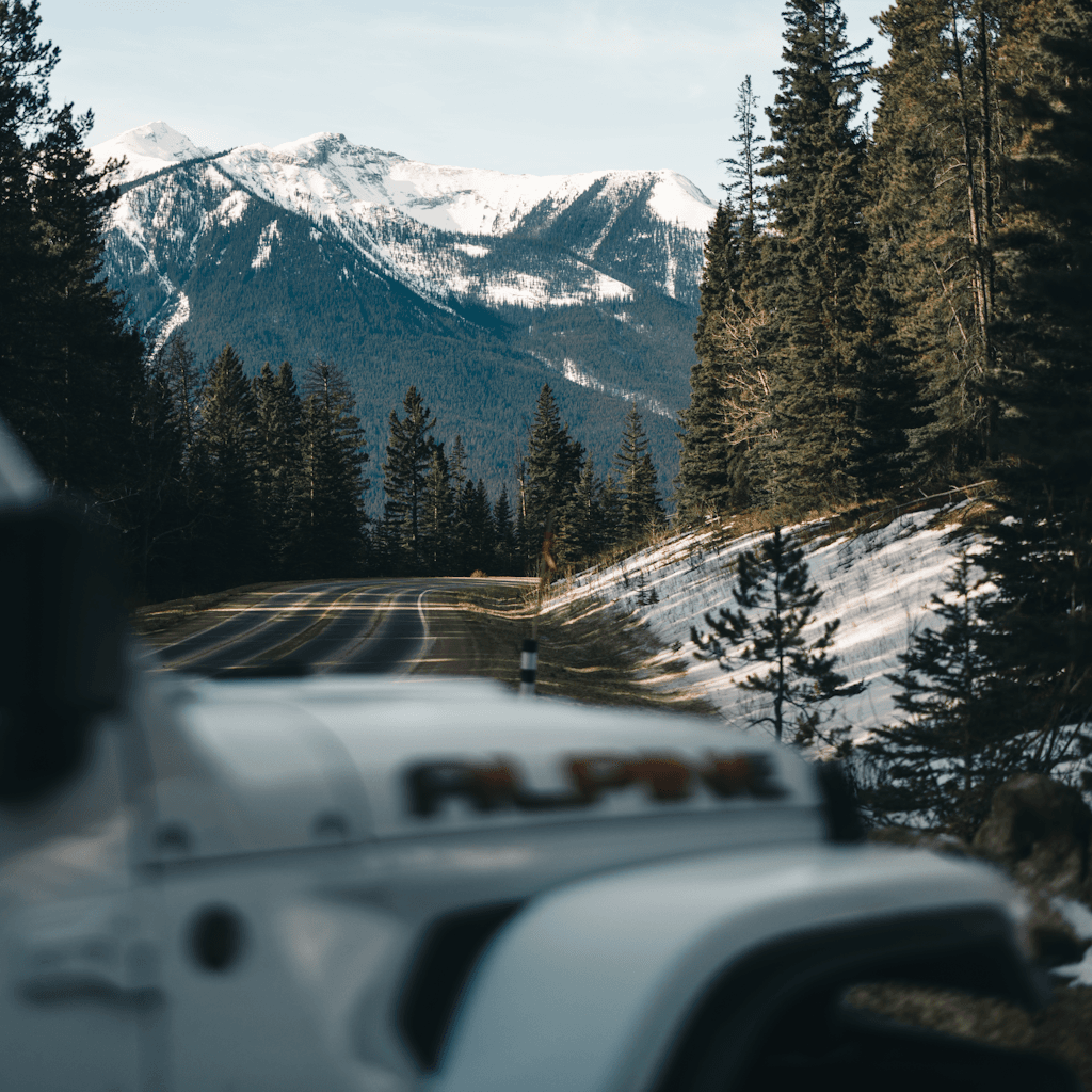 The scene is set outdoors along a winding mountain road amid a picturesque landscape.