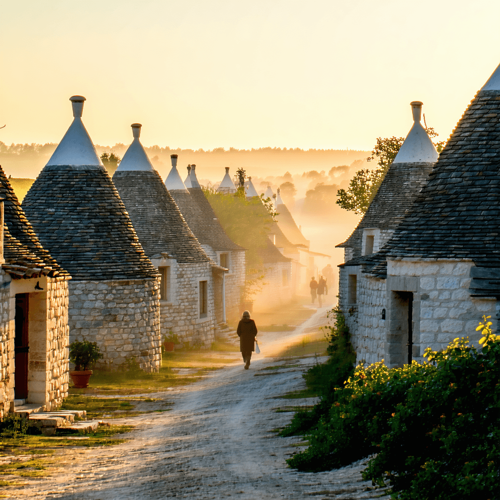 The scene captures an outdoor view of a quaint village during the daytime, under a clear, bright blue sky.