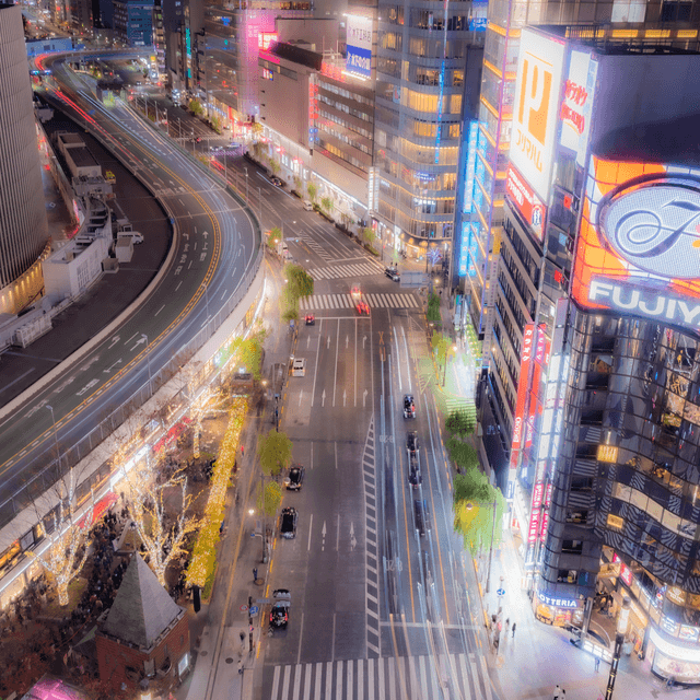 The scene is an urban nighttime setting, likely a bustling city center.