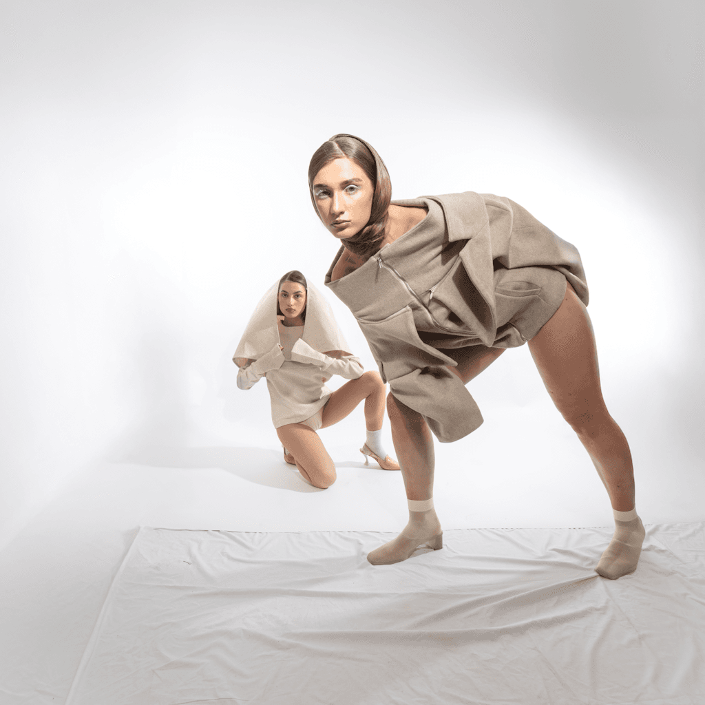 The scene is set in a minimalist indoor studio, defined by a stark white backdrop and well-lit by bright, even lighting simulating midday clarity.
