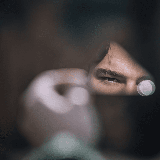 The scene is set indoors, with a close-up focus creating an intimate yet mysterious atmosphere.